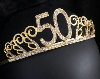 May include: Gold-colored tiara with clear rhinestones and the number 50 in the center.