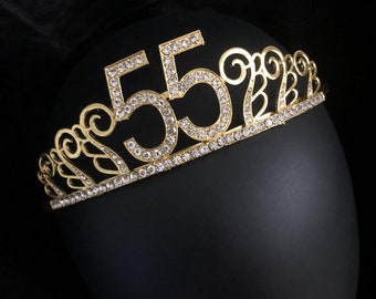 May include: Gold-colored tiara with clear rhinestones and the number 55 in the center.