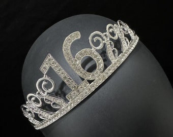 Könnte beinhalten: Silberne Tiara mit Strasssteinen, mit der Zahl 16.