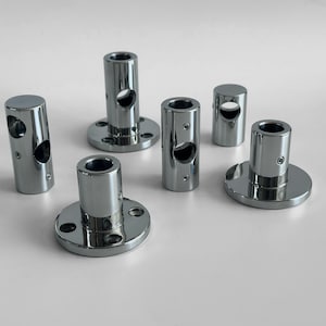 May include: Six chrome-plated metal pipe fittings with a round base and a hole in the center. The fittings are designed to connect pipes or rods.