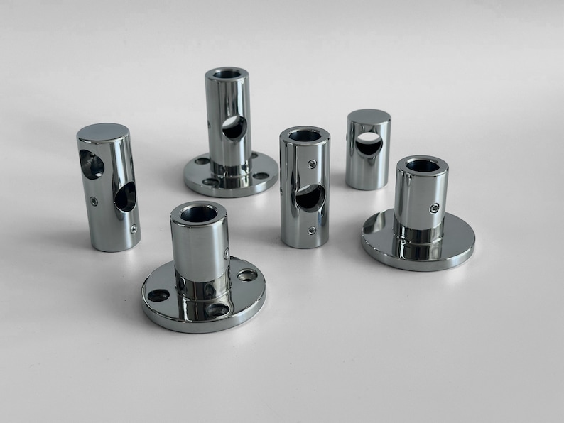 May include: Six chrome-plated metal pipe fittings with a round base and a hole in the center. The fittings are designed to connect pipes or rods.