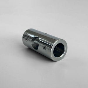 May include: A chrome-plated metal pipe connector with a hole in the center. The connector has a smooth, shiny finish.