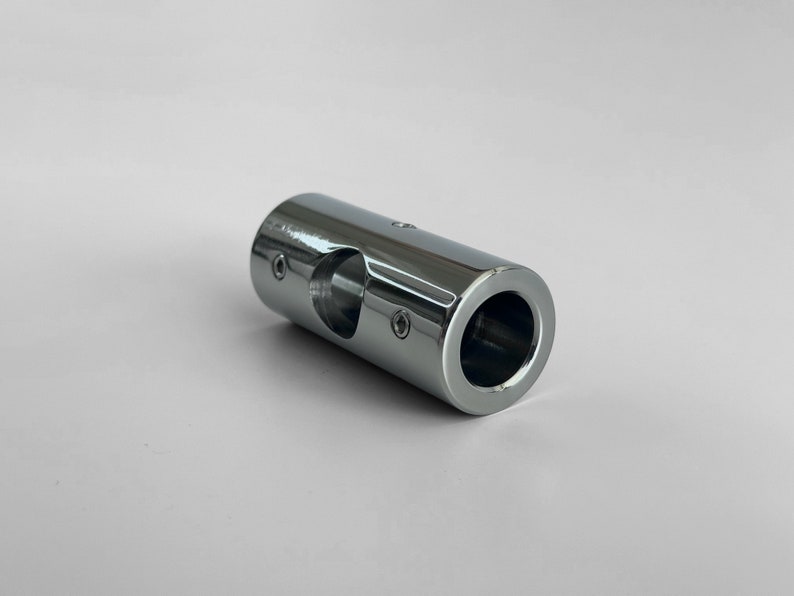 May include: A chrome-plated metal pipe connector with a hole in the center. The connector has a smooth, shiny finish.