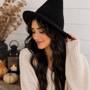 Peut inclure: Un chapeau de sorcière en crochet noir avec une couronne haute et pointue ainsi qu'un large bord légèrement incurvé. Le chapeau est fabriqué à partir d'un matériau en fil dense et texturé, présentant un motif de maille uniforme.