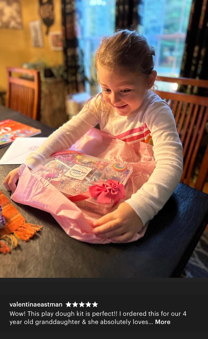 May include: A clear plastic rectangular storage container filled with various colorful play dough accessories, including small shaped cutters and decorative items. A white label on the lid features the text LIFE MAGIC HAPPY.