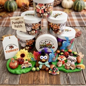 May include: A collection of clear plastic jars filled with small animal-shaped play dough accessories, including foxes, owls, and raccoons. The set features a turkey figure, a sunflower, and green play dough bases with labels reading Pumpkin Patch and Build A Play Dough Turkey.