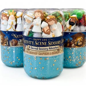Puede incluir: Tres frascos de plástico transparente rellenos de masa azul con purpurina y figuras en miniatura del nacimiento. Las etiquetas dicen Happy Life Nativity Scene Sensory Jar, A Sacred Sensory Adventure y For Sensory Crafting & Shaping, con un pesebre.