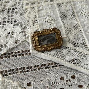 Piccola spilla in oro con capelli lavorati a maglia risalente all&#39;epoca vittoriana, realizzata con capelli umani e perle di semi