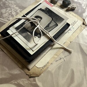 Puede incluir: Una pila de cartas y fotograf&iacute;as antiguas atadas con un cordel. Las cartas est&aacute;n amarillentas por el paso del tiempo y tienen notas escritas a mano. Las fotograf&iacute;as son en blanco y negro y muestran a un joven.