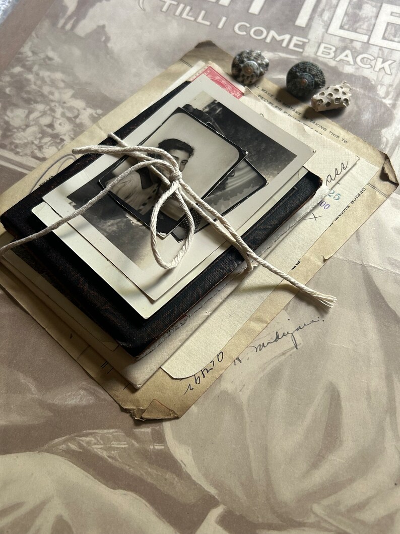 Puede incluir: Una pila de cartas y fotograf&iacute;as antiguas atadas con un cordel. Las cartas est&aacute;n amarillentas por el paso del tiempo y tienen notas escritas a mano. Las fotograf&iacute;as son en blanco y negro y muestran a un joven.