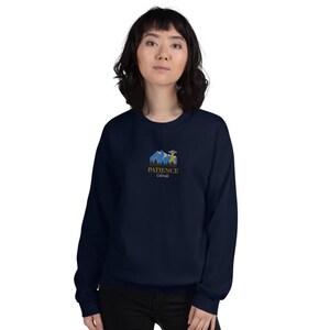 May include: A navy blue sweatshirt with a graphic of mountains, a UFO, and the text "PATIENCE Colorado".