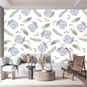 May include: White wallpaper with a repeating pattern of blue floral circles, green fern-like leaves, and red berries. The wallpaper is used as a backdrop for a white sofa, chair, and wooden furniture.