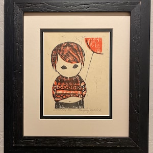 May include: A framed print of a child holding a red balloon. The child is wearing a red and black striped sweater. The print is signed "Little Boy Red" and "Margery Niblack".