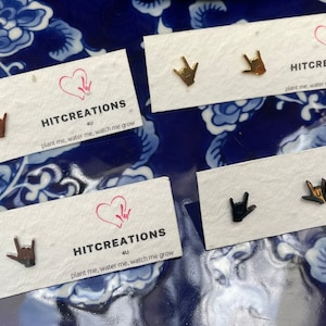 stainless steel earrings in the i love you handshape