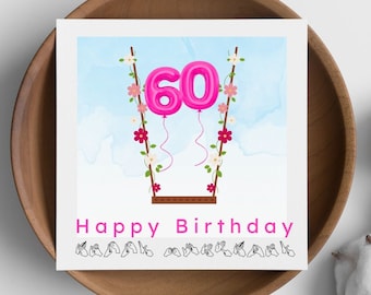 Può includere: Un biglietto di compleanno rosa e bianco con il numero 60 in palloncini rosa appesi a un'altalena. Il biglietto dice "Buon compleanno" in lettere rosa e la parola "compleanno" è firmata in Lingua dei Segni Italiana.