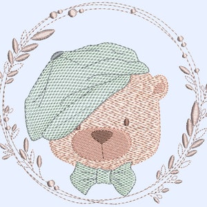 Può includere: Un orsacchiotto marrone che indossa un cappello blu chiaro e verde e un papillon verde. L'orso è circondato da una ghirlanda di foglie marroni e fiori bianchi.