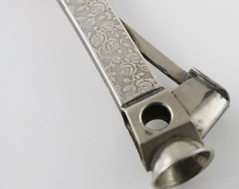 Puede incluir: Cortapuros de plata con diseño floral. El cortapuros tiene una cuchilla y un agujero redondo para cortar puros.