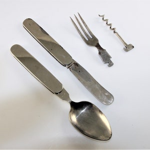 May include: A silver folding pocket knife with a spoon and fork, and a corkscrew.