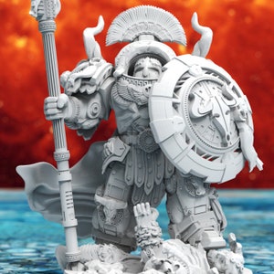 May include: A white plastic miniature figurine of a warrior in a helmet and armour, holding a staff and a shield with a bull's head design. The warrior is standing over a fallen figure.