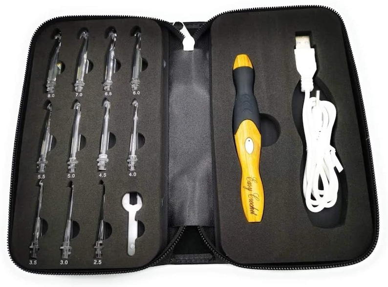 May include: A black zippered case with a set of 8 crochet hooks and a black and wood Easy Crochet electric crochet hook with a white USB charging cable. The crochet hooks are labeled with sizes 2.5, 3.0, 3.5, 4.0, 4.5, 5.0, 5.5, 6.0, 7.0, and 8.0.