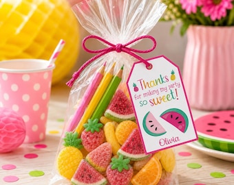 May include: A clear plastic favor bag filled with assorted fruit-shaped gummy candies and three colored pencils. A white tag tied with pink string features the text "Thanks for making my party so sweet!" and "Olivia" with watermelon illustrations.