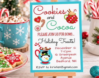 Op de afbeelding: Een rechthoekig uitnodigingsbord op een houten ezel met een blauwgroene rand. De tekst luidt: Cookies and Cocoa, PLEASE JOIN US FOR SOME... Holiday Treats! December 12, 7-10pm, 16 Greenpeak Avenue, Bedford, NH, RSVP to kristen@gmail.com.