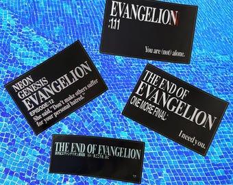 May include: Four black and white stickers with text from the anime series Neon Genesis Evangelion. The stickers are on a blue tiled surface. The text on the stickers reads: "Neon Genesis Evangelion", "Episode: 12", "She said, "Don't make others suffer for your personal hatred."", "Evangelion: 111", "You are (not) alone.", "The End of Evangelion", "One More Final:", "I need you.", "The End of Evangelion", "Air/まごころを、君に".