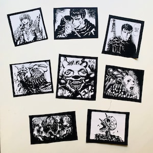 Peut inclure: Huit patchs thermocollants en noir et blanc représentant des personnages et des créatures de la série de mangas Berserk. Les patchs représentent Guts, Casca, le Chevalier du Crâne et divers démons.