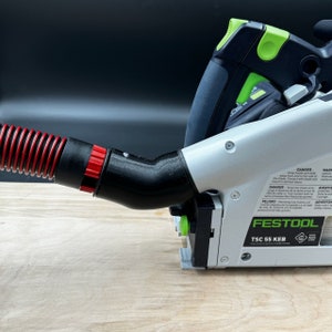 May include: A silver and black Festool TSC 55 KEB track saw with a red and black dust collection hose attached. The saw has a green handle and a black and green track.