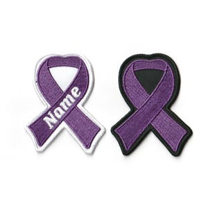 May include: Purple ribbon with white outline and the word "Name" embroidered on it. The ribbon is shown on a white background with a black outline version of the ribbon to the right.