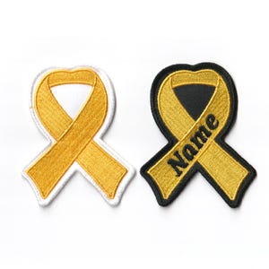 May include: Two yellow ribbon patches, one with a white background and the other with a black background. The black background patch has the word "Name" embroidered on it.