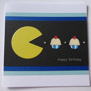 Biglietto di auguri di compleanno con Pacman che mangia la torta
