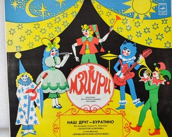 May include: A vintage record album cover featuring a cartoon band of puppets playing instruments under a circus tent. The album is titled "MBUYPU" and the text "Наш друг - Буратино" is below the band. The album cover is yellow, blue, black, and red.