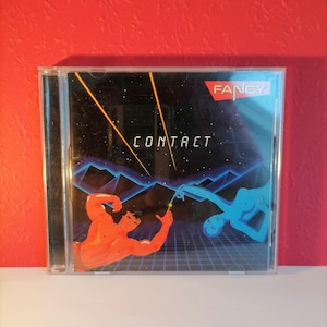 May include: A CD case with a black background and a blue and red illustration of two figures. The text "FANCY" is in red and the text "CONTRACT" is in white.