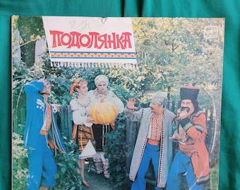 May include: A vintage vinyl record album cover featuring a group of four people dressed in traditional Ukrainian clothing. The album is titled "Подолянка" and features the text "Ансамбль пісні і танцю" at the bottom.