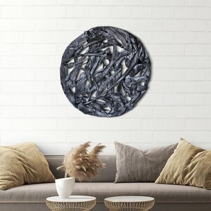 May include: A round wall decor made of interwoven driftwood branches, painted in a dark gray color. The branches are arranged in a circular pattern, creating a unique and organic design.