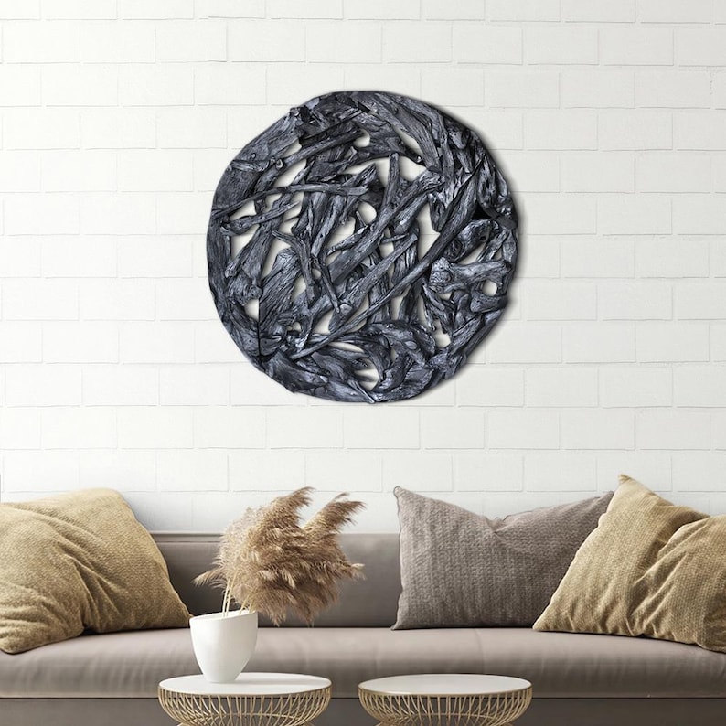 May include: A round wall decor made of interwoven driftwood branches, painted in a dark gray color. The branches are arranged in a circular pattern, creating a unique and organic design.