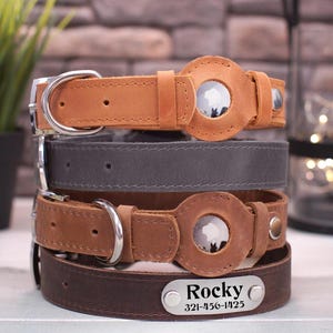 Può includere: Quattro collari per cani in pelle impilati uno sopra l'altro. Il collare superiore è marrone con una fibbia argentata e un'etichetta rotonda argentata con una silhouette di un cane. Il secondo collare è grigio, il terzo è marrone e il collare inferiore è marrone con un'etichetta argentata che dice "Rocky 321-456-1425".