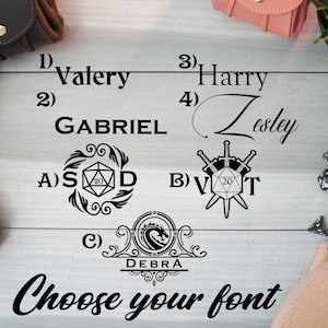 Pode incluir: Uma superf&iacute;cie de madeira branca com texto e imagens pretas. O texto inclui os n&uacute;meros de 1 a 4, seguidos de nomes, e as letras A, B e C. A imagem inclui um design de espada e dados, um design floral com um dado, e um bras&atilde;o com um drag&atilde;o.