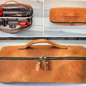 May include: A tan leather travel case with a black zipper and a handle. The case is open, revealing a hair dryer and attachments. The hair dryer has a red accent. The case is closed in other images.