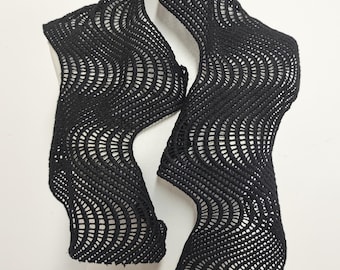 May include: Black crocheted scarf with a wavy pattern. The scarf is draped over a white mannequin.