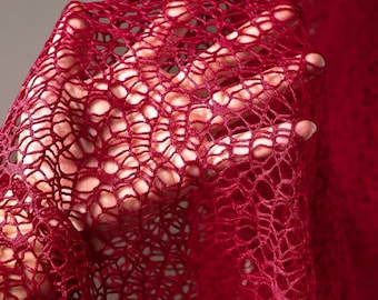 May include: A close-up of a red crocheted fabric with a delicate, intricate pattern. The fabric is soft and flowing, with a subtle sheen.