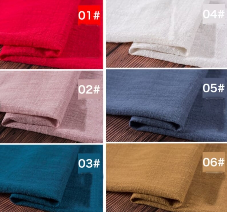May include: Six fabric swatches in different colors, folded and displayed on a wooden surface. The swatches are labeled with numbers 01 through 06. The colors are red, pink, blue, teal, brown, and white.