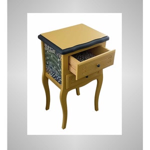 May include: A small, two-drawer nightstand with a mustard yellow finish and black trim. The top drawer is open, revealing a floral patterned lining.