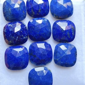 Peut inclure: Dix pierres précieuses lapis-lazuli taillées en coussin à facettes disposées en grille. Chaque pierre bleu profond présente une surface polie avec des inclusions naturelles de pyrite dorée et un motif géométrique à facettes.
