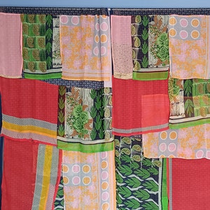 Puede incluir: Una cortina de patchwork hecha de retazos de tela de colores. La cortina está compuesta por diferentes patrones y colores, incluyendo rosa, rojo, verde y amarillo. La cortina está colgada de una barra y está lista para ser usada.