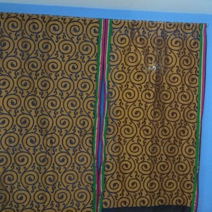 Puede incluir: Dos cortinas marrones con un patrón de espiral azul y marrón. Las cortinas tienen ribetes verdes, rosas y azules.
