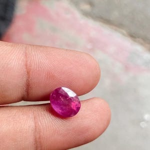 Peut inclure: Une pierre précieuse ovale de couleur rose vif avec des facettes.
