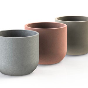 May include: Three round, cylindrical planters in different colors. The planter on the left is gray, the middle planter is a light brown, and the planter on the right is a light green.