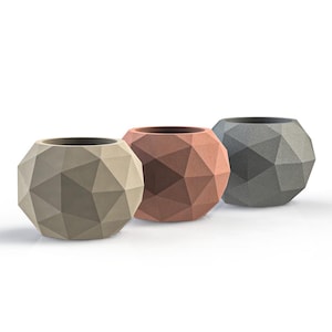May include: Three geometric planters in different colours: grey, brown, and beige. The planters are made of a textured material and have a rounded shape.